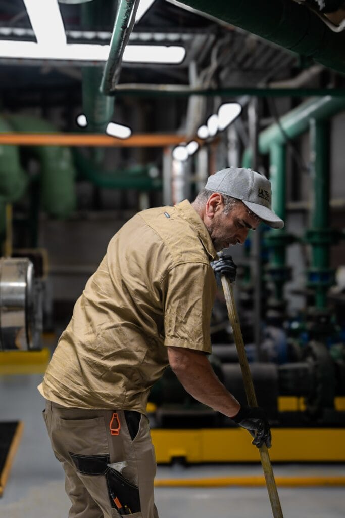 MEFS crew rolling epoxy coating in a commercial plant room